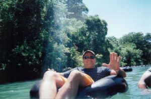 Man floating down river in inner tube