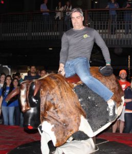Man riding mechanical bull in uShip shirt