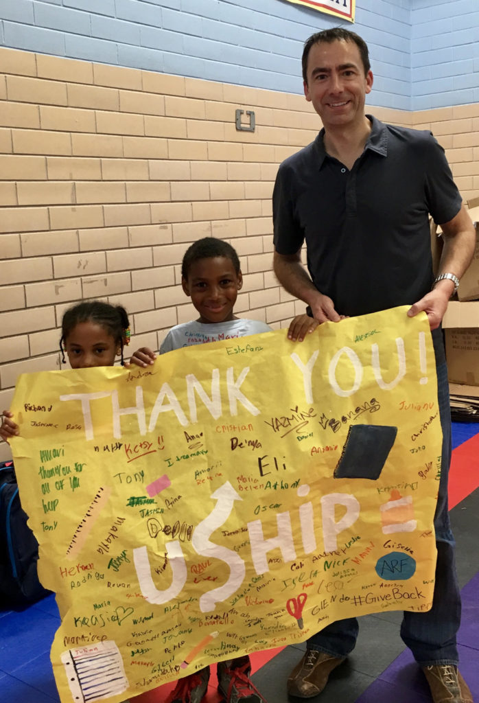 Mike Williams at Andy Roddick Foundation holding sign with children