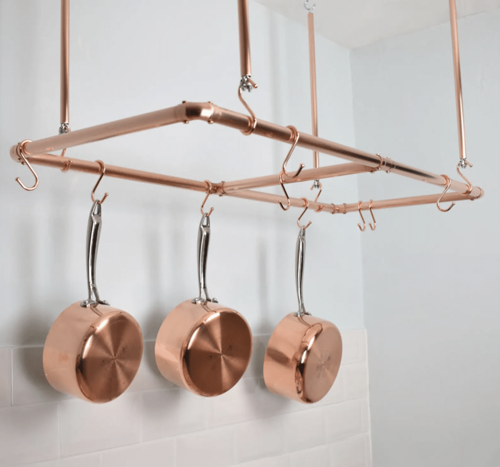 copper pots hanging from copper stand
