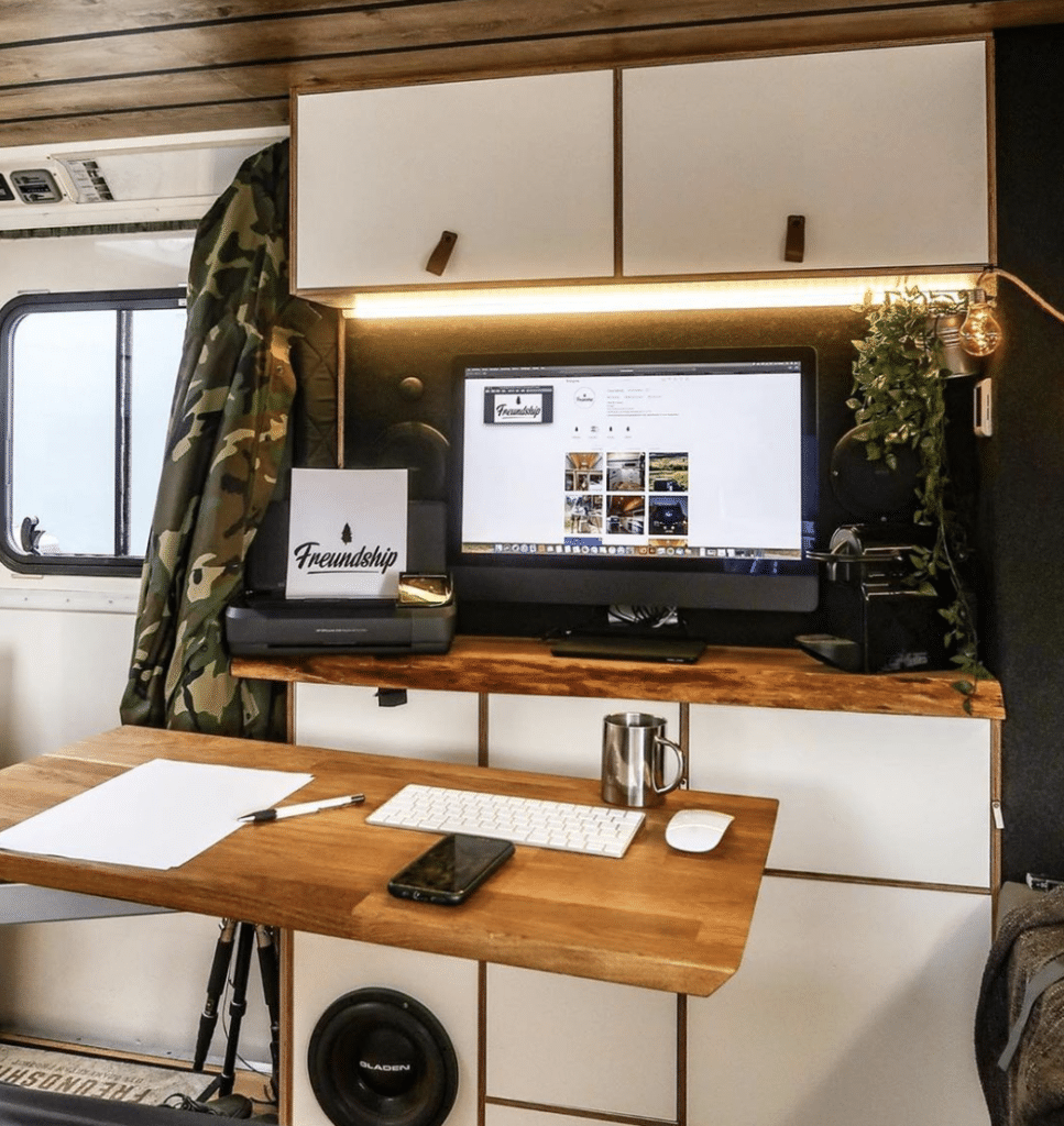 home office setup with monitor and keyboard in converted van space
