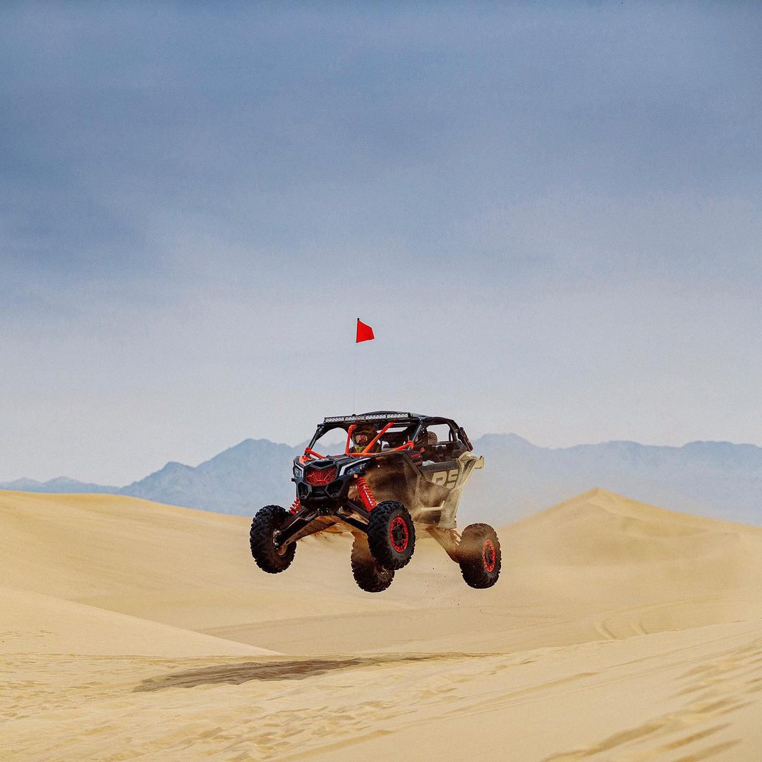 utv off road vehicle on a big jump over sand dunes