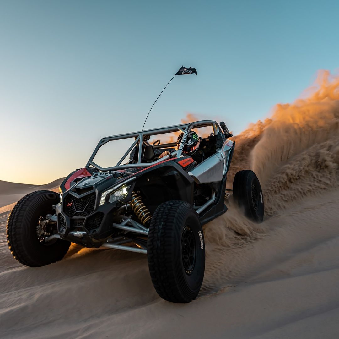 utv off road vehicle riding through sand dunes