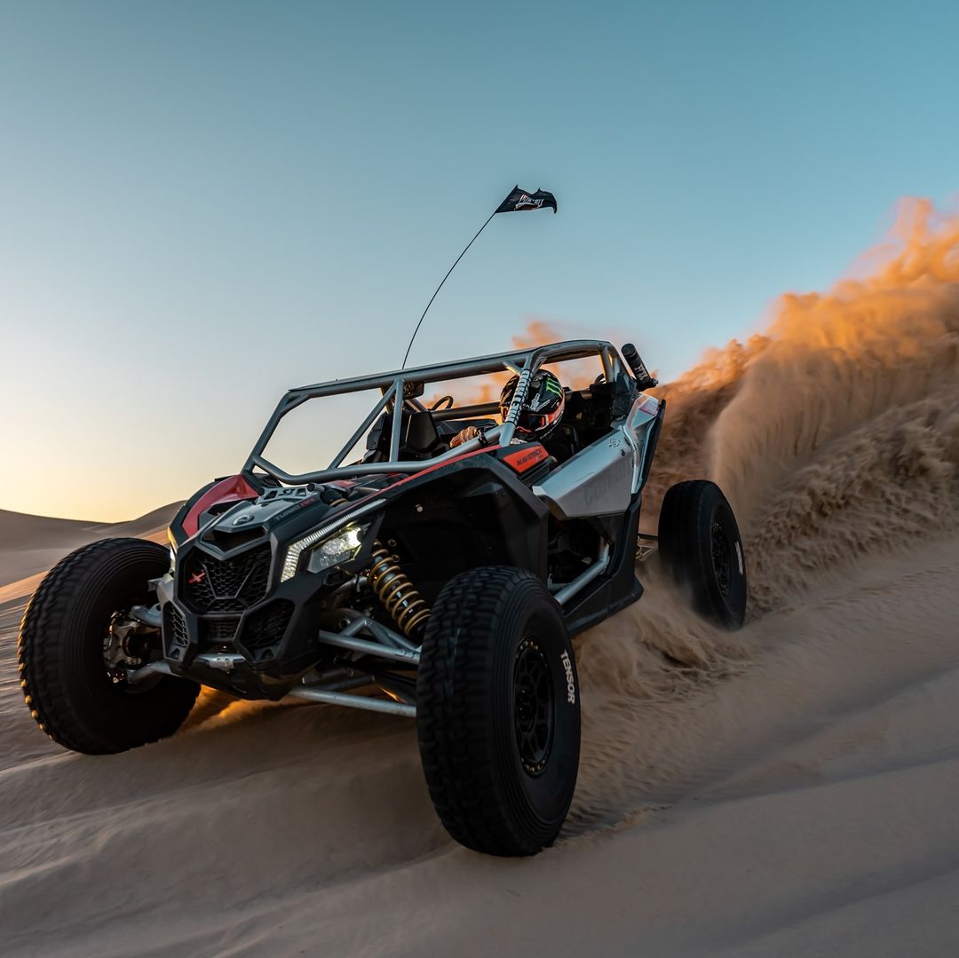 utv off road vehicle riding through sand dunes