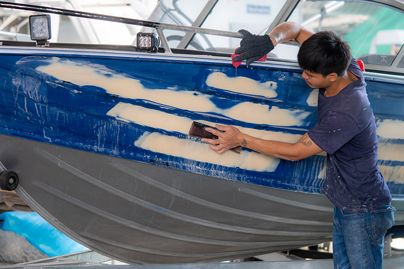 man with boat restoration project