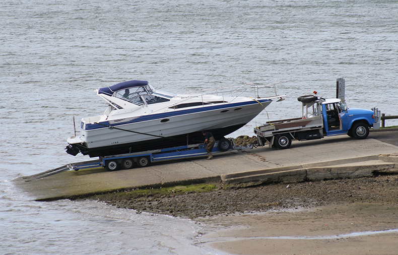 boat shipping company hauling motor boat out of water