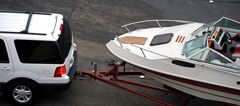 closeup of white suv pulling white boat 