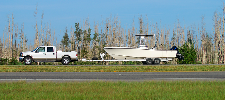 white truck hauling boat on trailer 