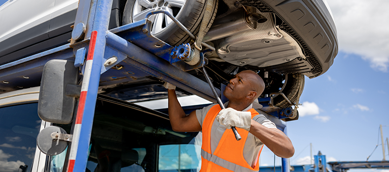 car transporter securing a vehicle on an open trailer to keep car shipping costs lower