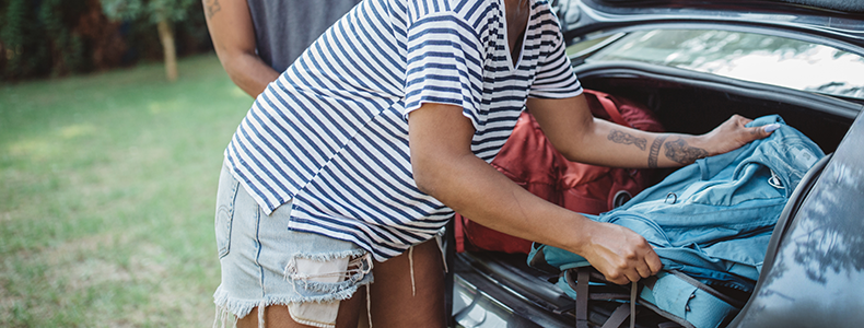 Woman removing personal items from high-value car before shipping