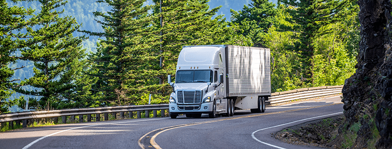 enclosed auto transport vehicle traveling down road
