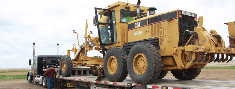 large heavy equipment transport on flatbed
