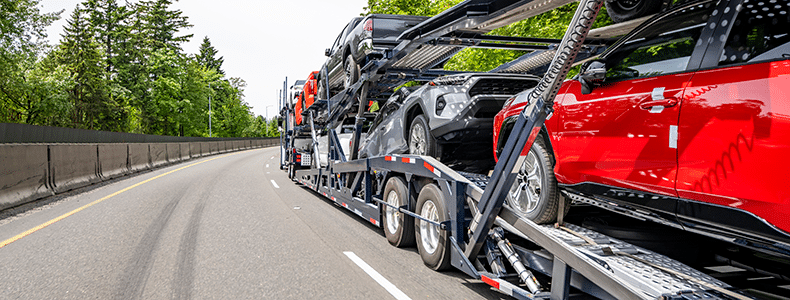 Open vehicle shipping trailer on the road