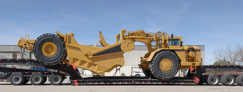 heavy equipment shipping on flatbed