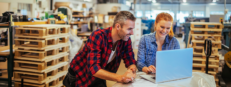 two warehouse workers looking at digital bill of lading on computer