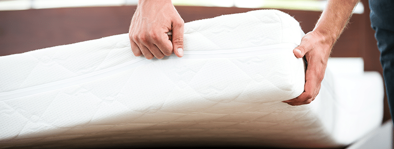 Person lifting a mattress for household goods shipping