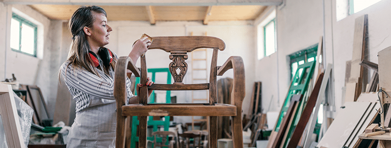 business owner preparing refurbished wood chair for small furniture delivery