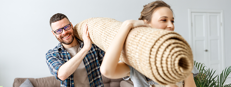 couple lifting a rug and preparing to ship a rug