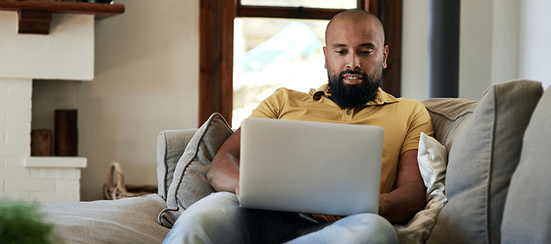 man on laptop shopping for shipping options without tariffs