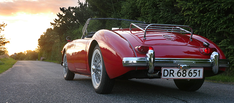 red classic car on the road after shipping