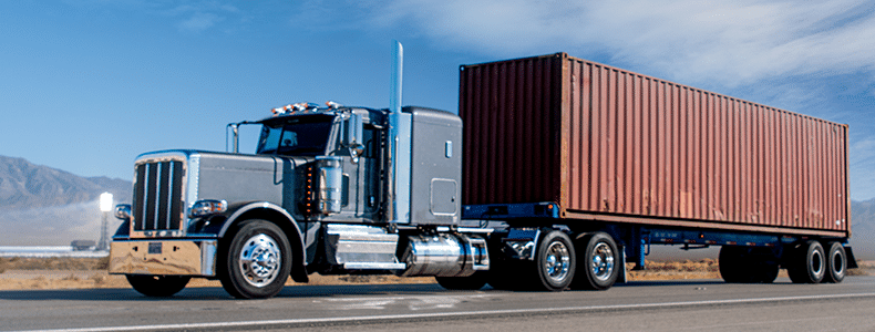 semi-trailer truck carrying large container on desert road