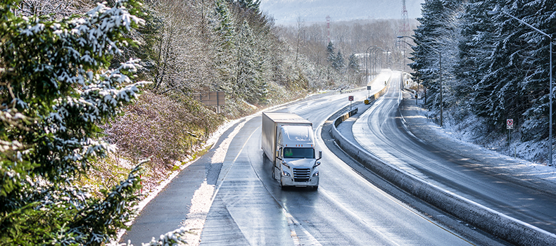 truck driving down road during extreme winter weather