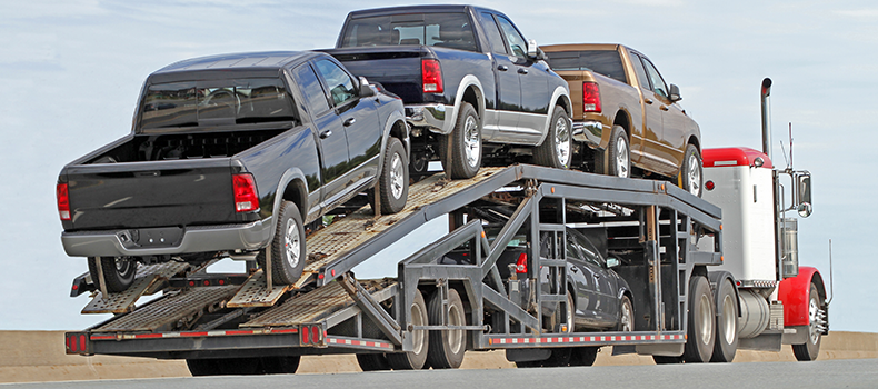 large trucks loaded on open trailer truck