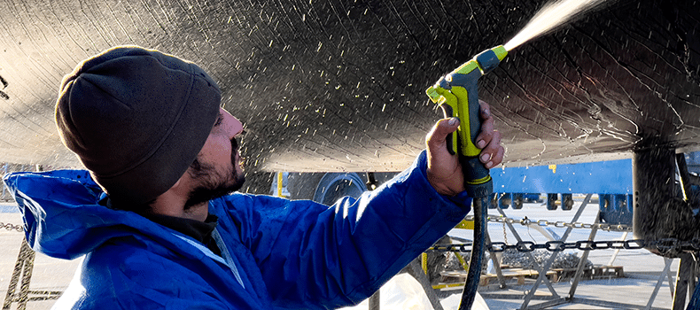 man cleaning boat before transport