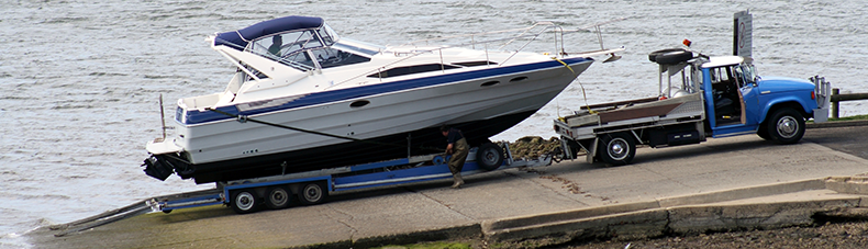 truck hauling a boat on an open trailer