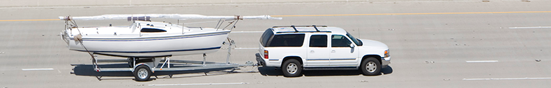 SUV hauling boat with open trailer