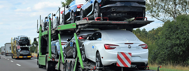 vehicles being hauled on open trailer